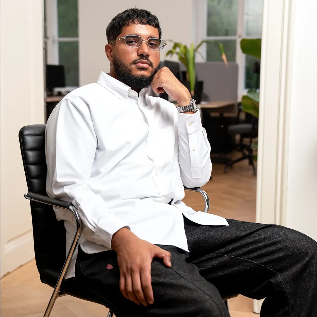 Umar, Data & AI Engineer at the AI agency OSTWERK, sitting in the office in Vienna