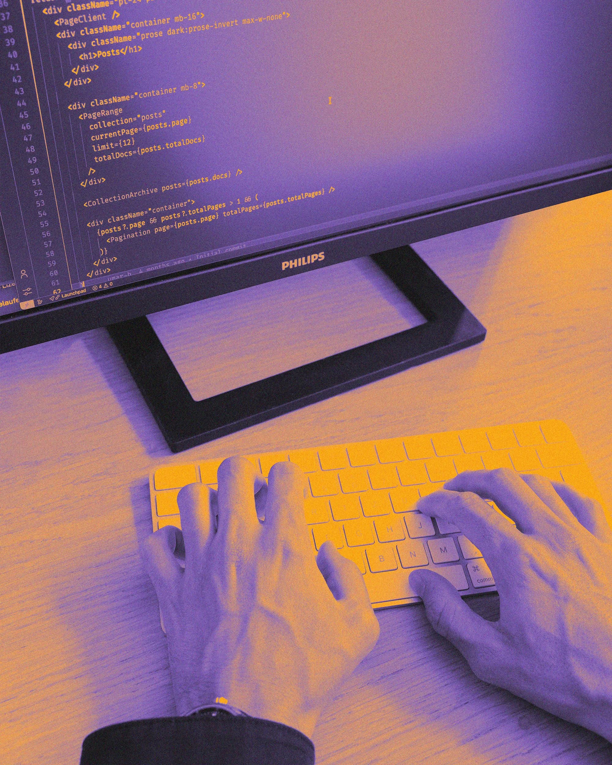 Hands typing on a keyboard in front of a monitor with code, tinted in violet and orange