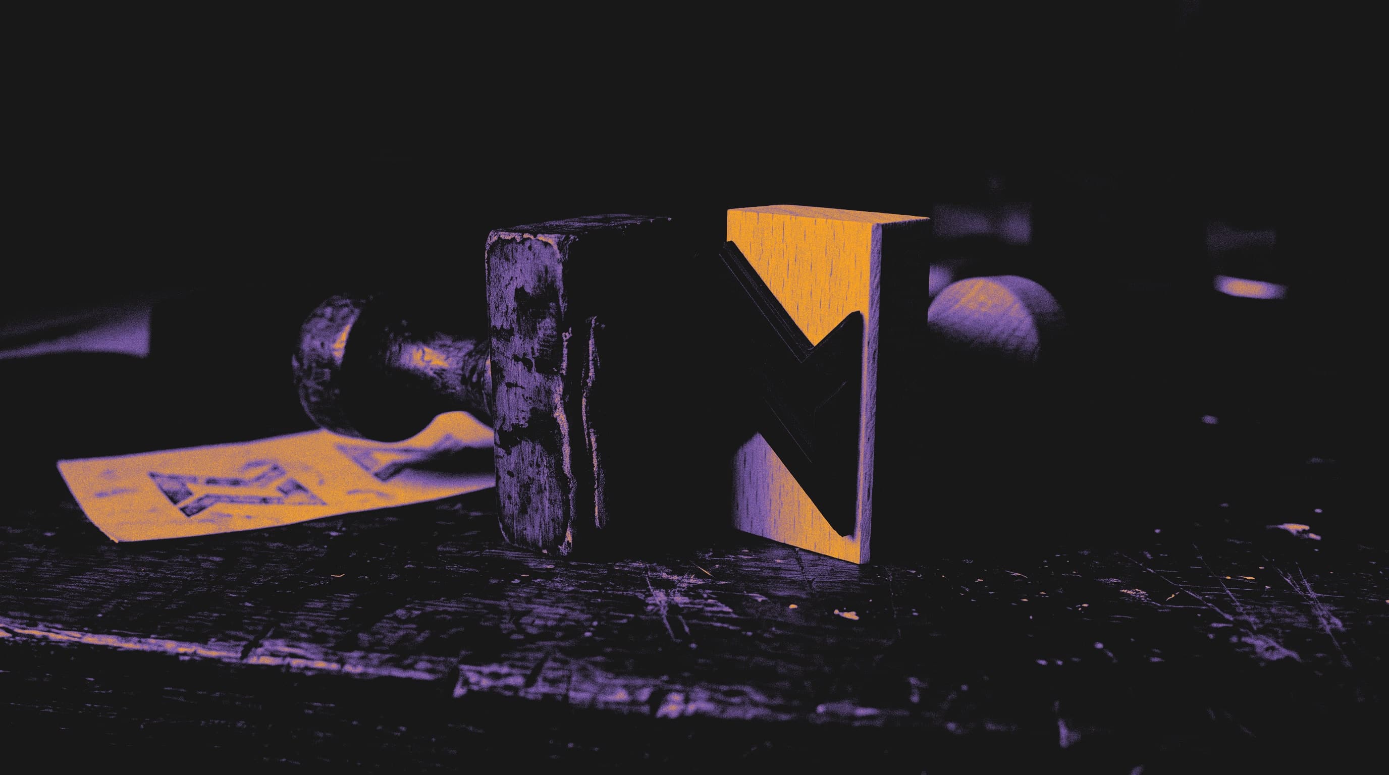 Alter abgenutzter Stempel neben einem neuen Stempel mit derselben abstrakten Form auf einem dunklen Holztisch